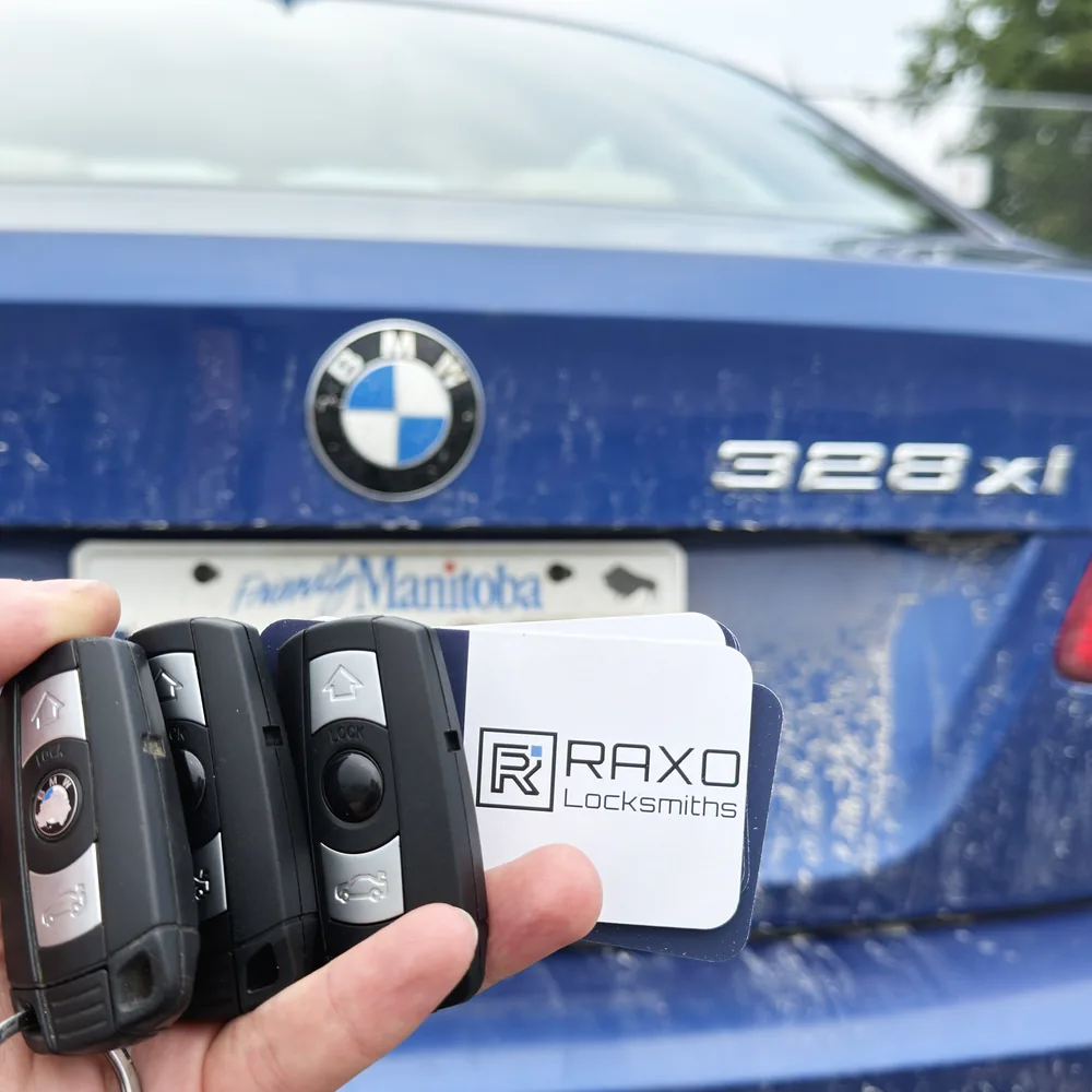 Two spare BMW proximity keys added alongside the customer's original for a BMW 328xi in Winnipeg, RAXO card at the tailgate