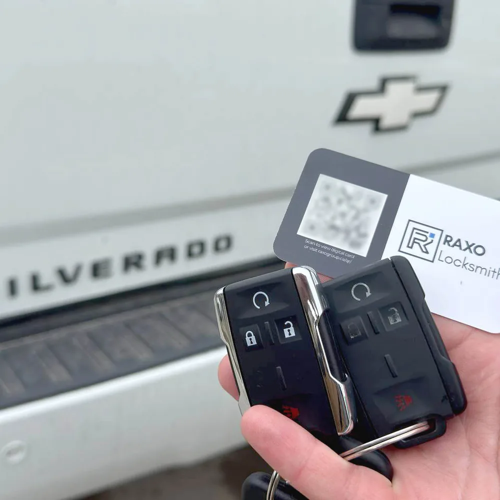 Two Chevrolet Silverado remote-start keys cut and programmed in Winnipeg, RAXO card at the Silverado tailgate