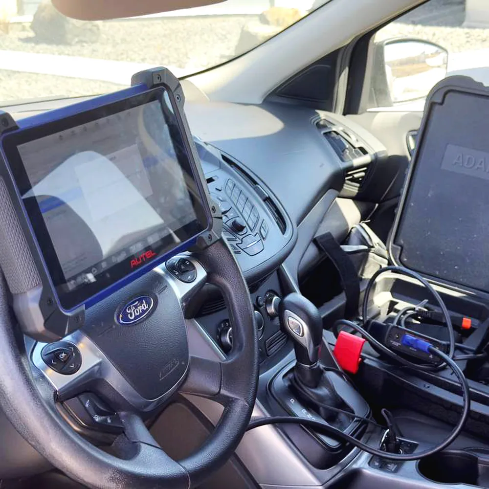 Dealer-level key-programming setup at the wheel — diagnostic tablet inside a customer's Ford in Winnipeg