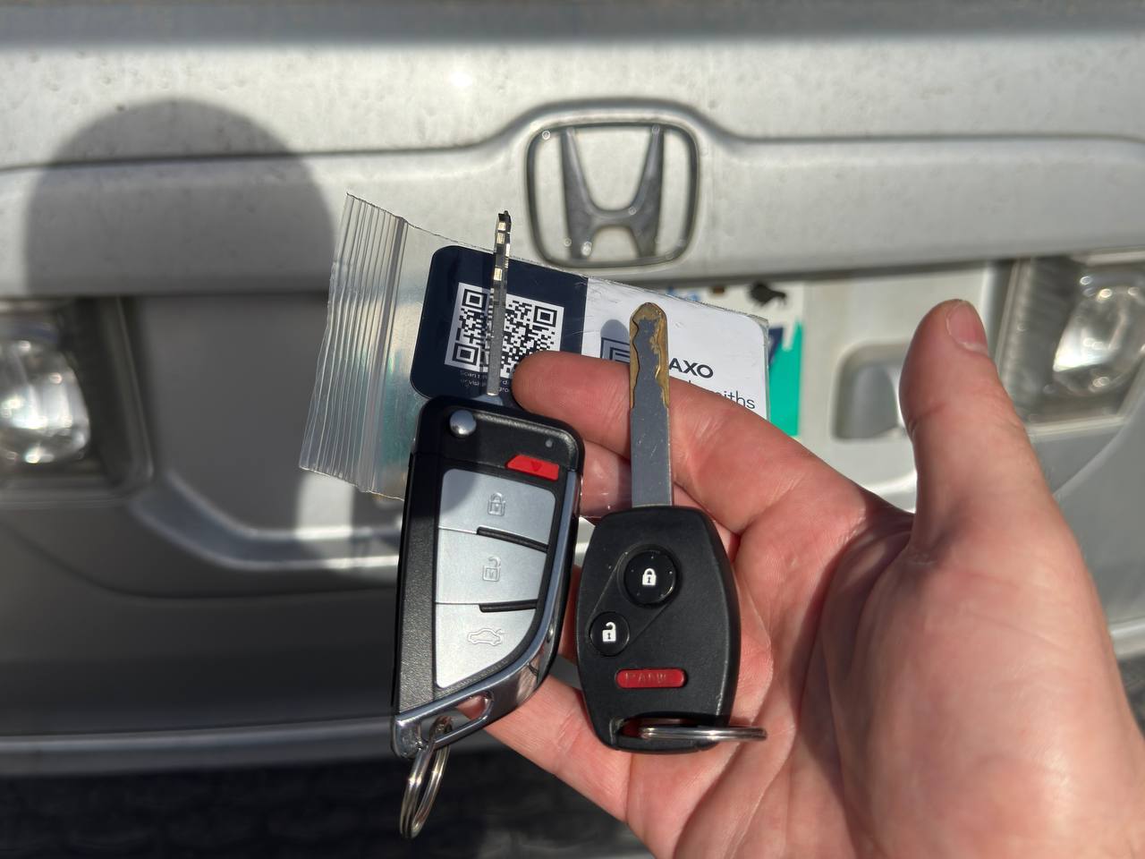 Freshly cut Civic or CR-V key in hand, Honda interior or grille visible in background