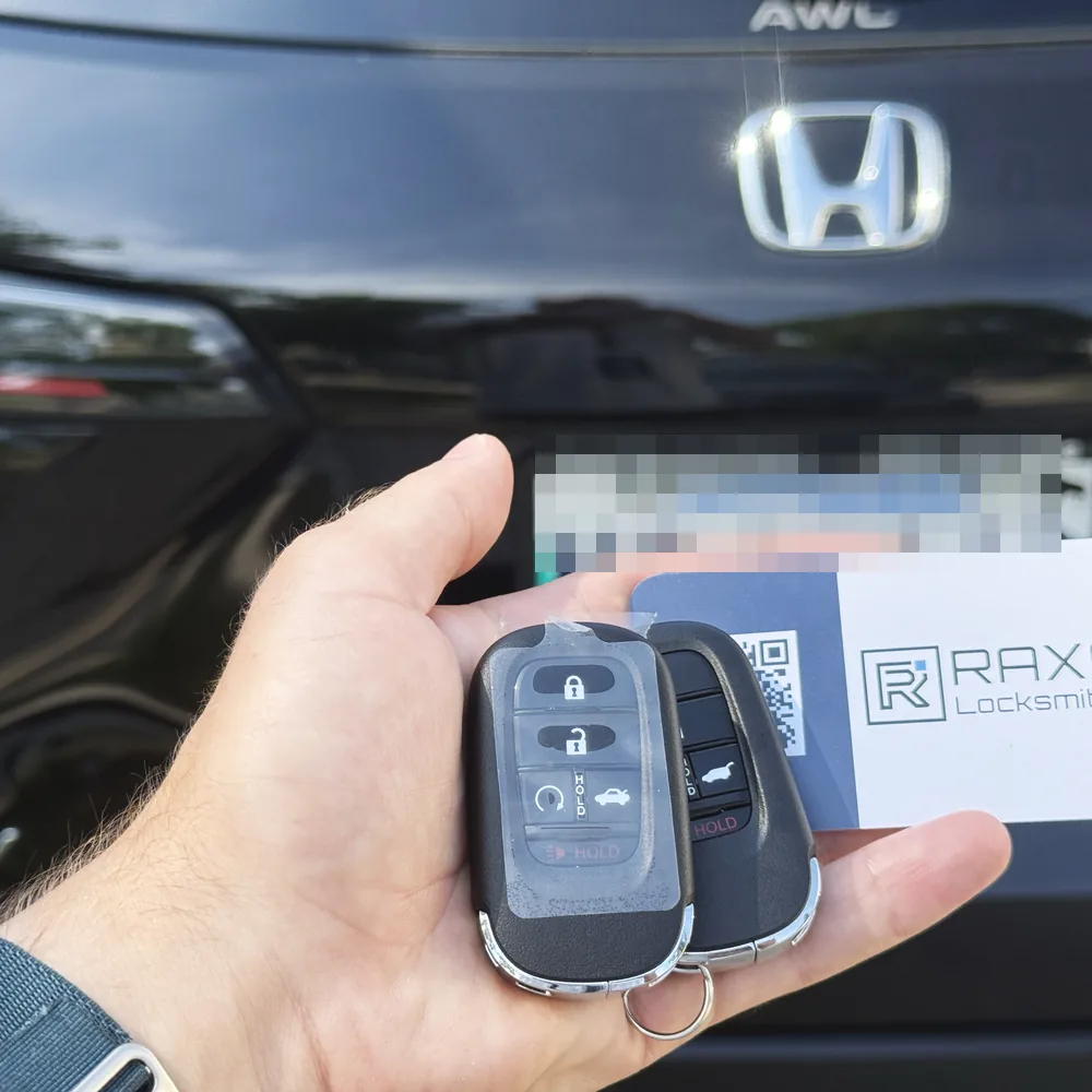 A new Honda HR-V smart key beside the original, cut and programmed on-site in Winnipeg, RAXO card at the tailgate