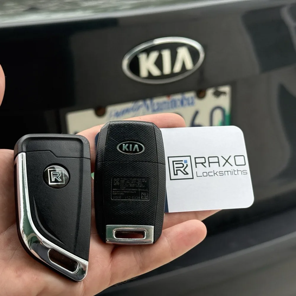 A spare flip key beside the factory Kia flip key, cut and programmed in Winnipeg