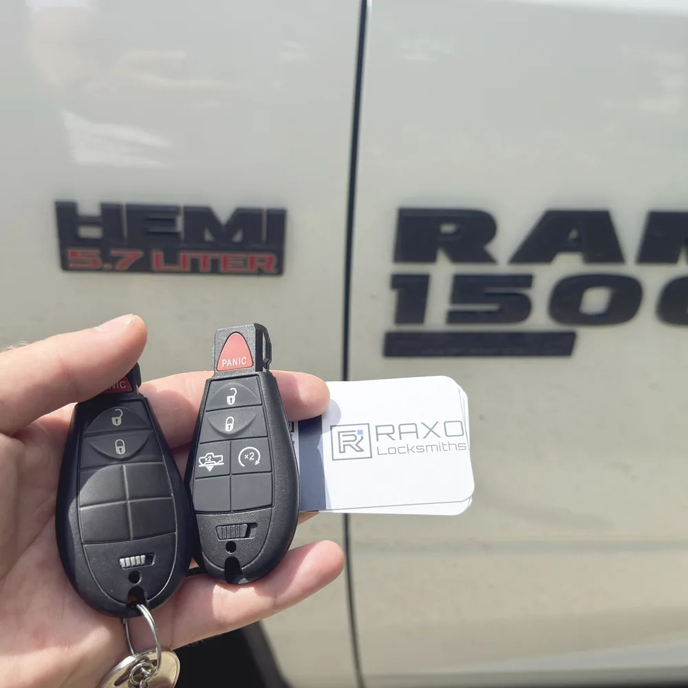 Two FOBIK keys I cut and programmed for a white Ram 1500 in Winnipeg, RAXO card in frame